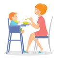 Mother feeds her baby in high chair