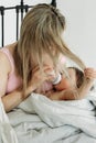 A mother feeds her one-year-old daughter formula from a bottle, wrapping her in a blanket Royalty Free Stock Photo