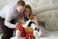 mother feeds newborn baby breast milk on bed in bedroom next to dad and dog. Royalty Free Stock Photo