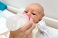 Mother feeds their newborn baby with bottle