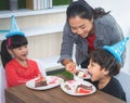 Mother feeing her children birthday cake in a brithday party Royalty Free Stock Photo