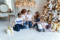 Mother and five children near Christmas tree at home