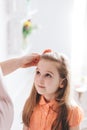 Mother fixing her young daughter`s hair