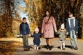 Mother with four kids in autumn park. Family walk in fall forest Royalty Free Stock Photo