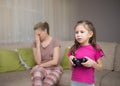 Mother frustrating that her daughter playing video games.