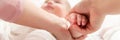 Mother gently massaging her baby boy while applying body lotion to his skin. Baby massage banner. Hands close up. Royalty Free Stock Photo