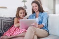 Mother, girl kid and relax with tablet for streaming, elearning or online games with bonding or together at family home Royalty Free Stock Photo