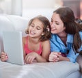 Mother, girl and kid on sofa with tablet for streaming, elearning or online games with bonding or together at family Royalty Free Stock Photo