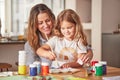 Mother, girl and painting art in house studio, home or creative space with brush, oil paint or palette. Happy smile mom Royalty Free Stock Photo
