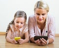 Mother and girl playing with mobile phones indoor Royalty Free Stock Photo