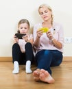 Mother and girl playing with mobile phones indoor Royalty Free Stock Photo