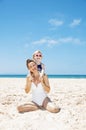 Mother and girl in swimsuits at sandy beach on a sunny day Royalty Free Stock Photo