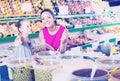 Mother with girl taking pickled olives in marketplace Royalty Free Stock Photo