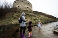 Mother and girls walk up the wet path to an ancient medieval fortress in rain. Terebovlia castle, Ukraine