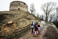 Mother and girls walk up the wet path to an ancient medieval fortress in rain. Terebovlia castle, Ukraine