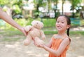 Mother give a teddy bear doll for her daughter in the park outdoor. Gift from mom for girls. Close-up happy kid with smiling Royalty Free Stock Photo