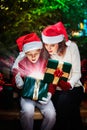 Mother gives her child a Christmas gift box with light rays Royalty Free Stock Photo