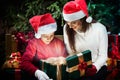 Mother gives her child a Christmas gift box with light rays Royalty Free Stock Photo