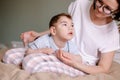 Mother gives a massage to child with cerebral palsy. Rehabilitation therapy at home.