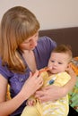 Mother gives to the sick baby medicine by means of the batcher Royalty Free Stock Photo