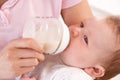 Mother Giving Bottle To Baby Boy At Home