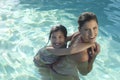 Mother Giving Daughter Piggy Back In Swimming Pool Royalty Free Stock Photo