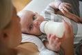 Mother giving her baby boy bottle of milk. Royalty Free Stock Photo