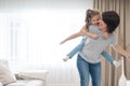 Mother giving joyful piggyback ride to her daughter, having fun at home, single mother happy family concept Royalty Free Stock Photo