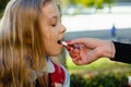 Mother giving pill to her daughter