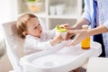 Mother giving spout cup with juice to baby at home Royalty Free Stock Photo