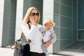 Mother going to work and talking on the phone with baby in her hands Royalty Free Stock Photo
