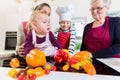 Mother, grandmother and children preparing meal in kitchen Royalty Free Stock Photo