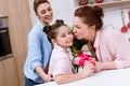 mother and grandmother presenting gift and flowers to daughter Royalty Free Stock Photo