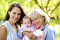 Mother and grandmother smiling with baby outdoors Royalty Free Stock Photo