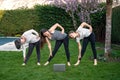 Mother, grandmother and teen daughter practicing fitness lesson online outdoors