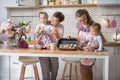 Mother and grandmother with two little daughters in the kitchen Royalty Free Stock Photo