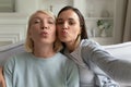 Mother and grownup daughter posing making selfie webcam view