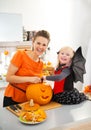 Mother with halloween dressed daughter carving Jack-O-Lantern Royalty Free Stock Photo
