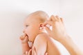 Mother hand cleaning baby ear with cotton swab Royalty Free Stock Photo