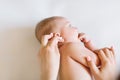 Mother hand cleaning baby ear on towel Royalty Free Stock Photo