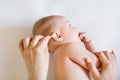 Mother hand cleaning baby ear on towel