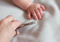 Mother hand cutting nail to small baby