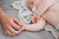 mother hand gently caress sleeping baby bed