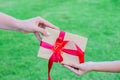 Mother hand giving a gift box with red ribbon to her child Royalty Free Stock Photo