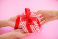 Mother hand giving a gift box with red ribbon to her kid Royalty Free Stock Photo
