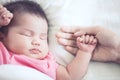 Mother hand holding asian newborn baby girl hand while she sleep Royalty Free Stock Photo