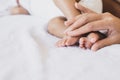 Mother hands holding baby feet lying on a comfortable bed at home,Family concept Royalty Free Stock Photo