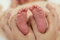 Mother hand holding newborn baby feet on bed Royalty Free Stock Photo