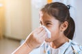 Mother hand holding tissue and help sick daughter wiping and cleaning nose in hospital