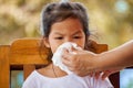 Mother hand holding tissue and help sick daughter wipingp